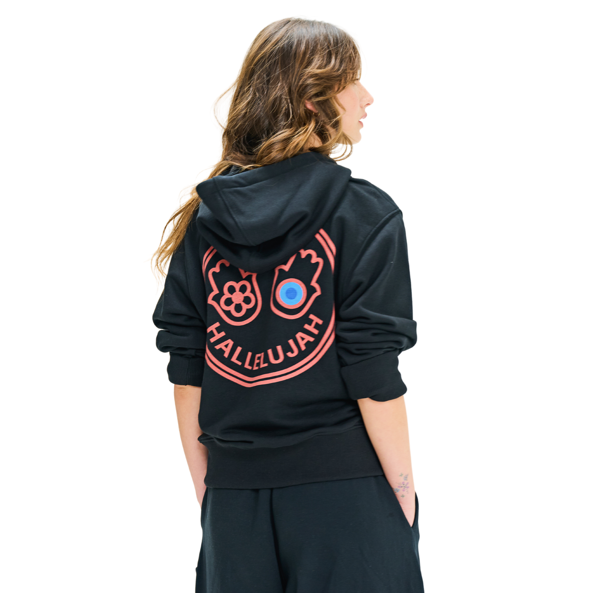 Back view of female model in long-sleeve hoodie with printed graphic logo, handmade cowrie shells, and woven tassel details