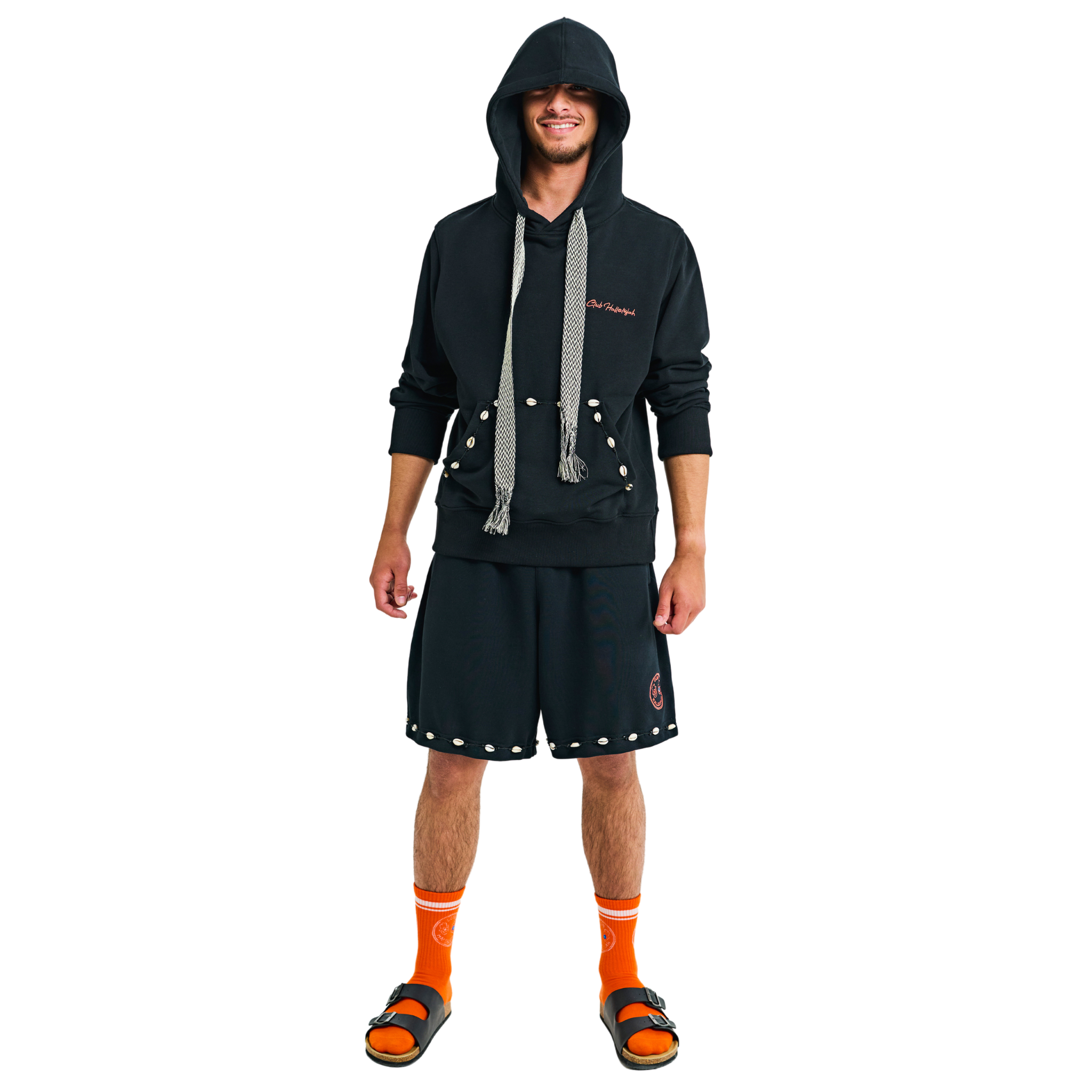 Male model front view wearing embroidered long-sleeve hoodie with handmade cowrie shells and braided tassels