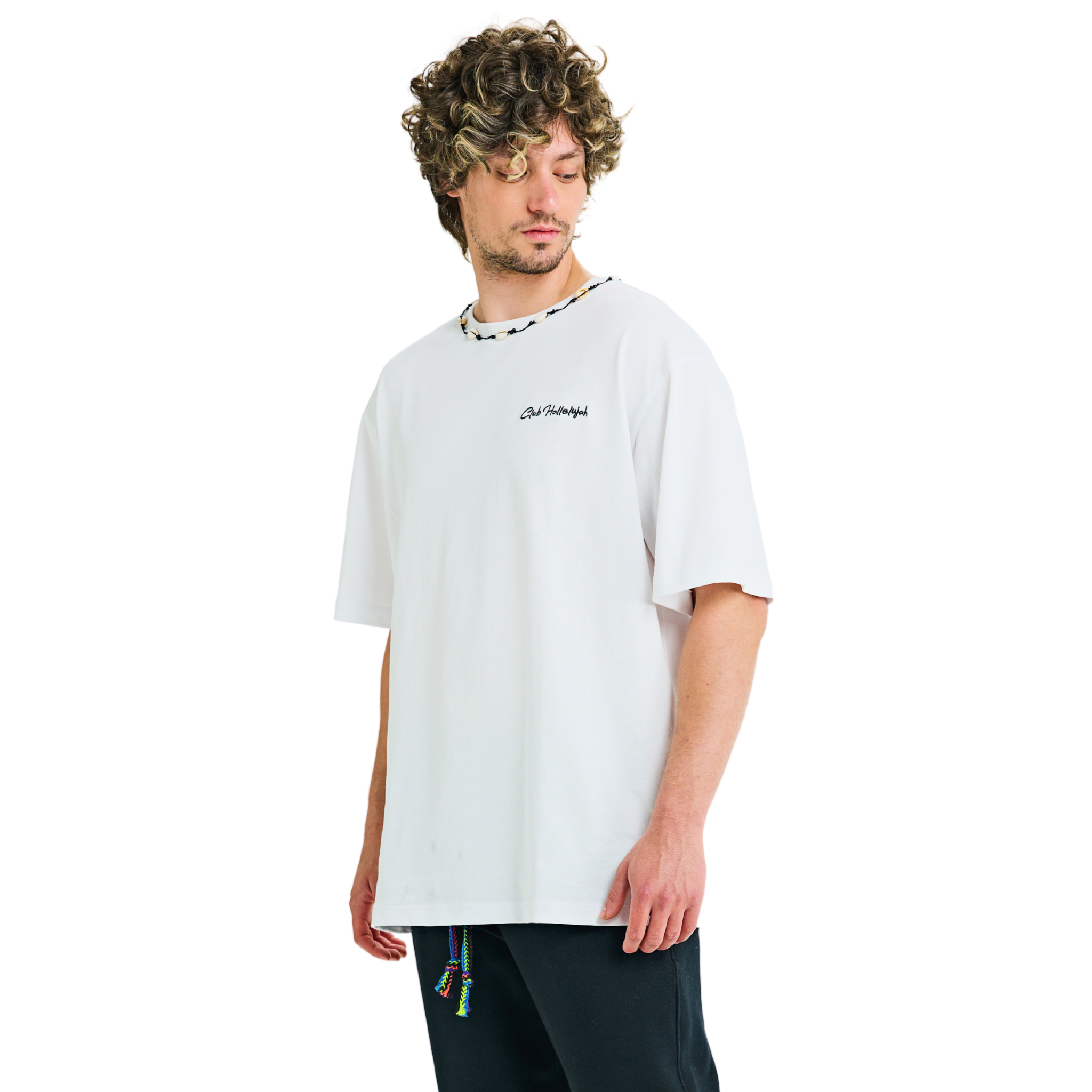 Model in white oversized T-shirt, side view, showing 'Club Hallelujah' embroidery and cowrie shell neckline