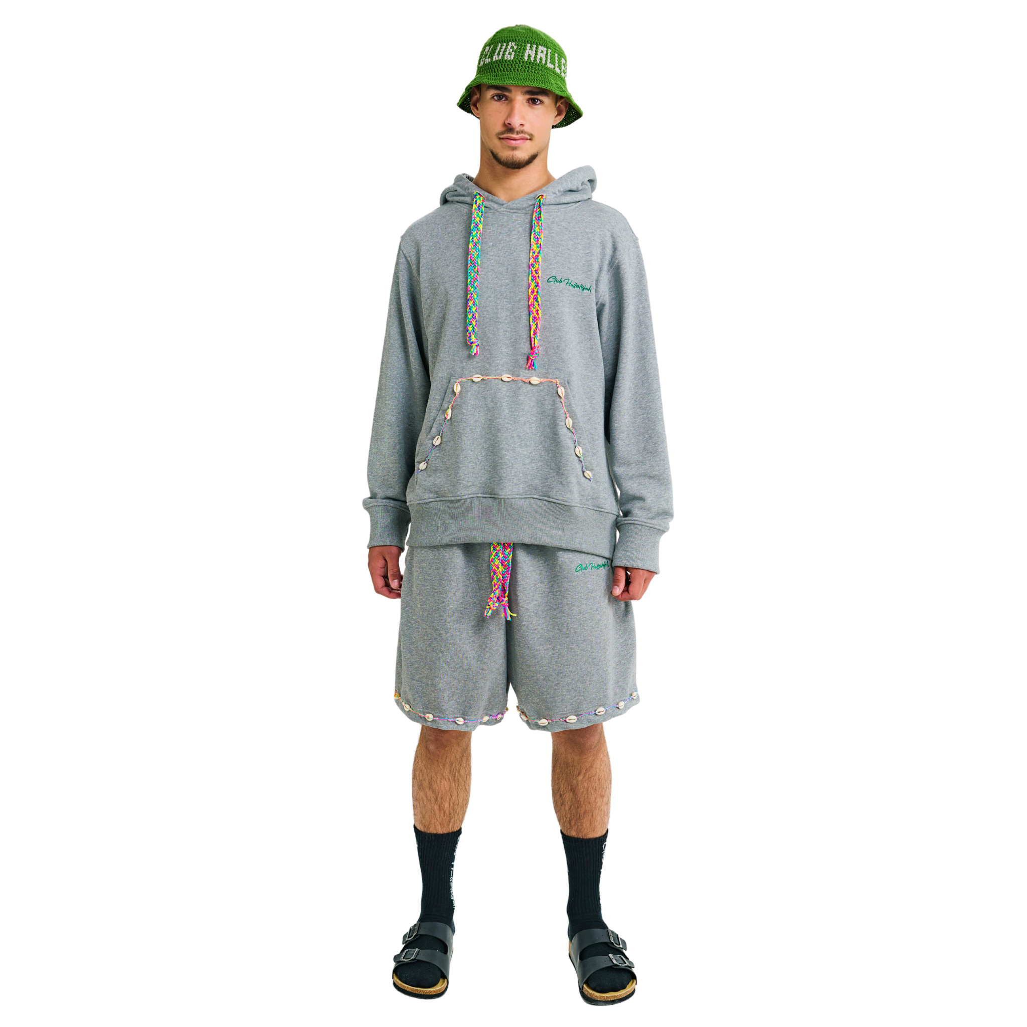 Front view of male model wearing unisex grey hoodie and shorts set with embroidered details, hand-woven drawstrings, and cowrie shell trims