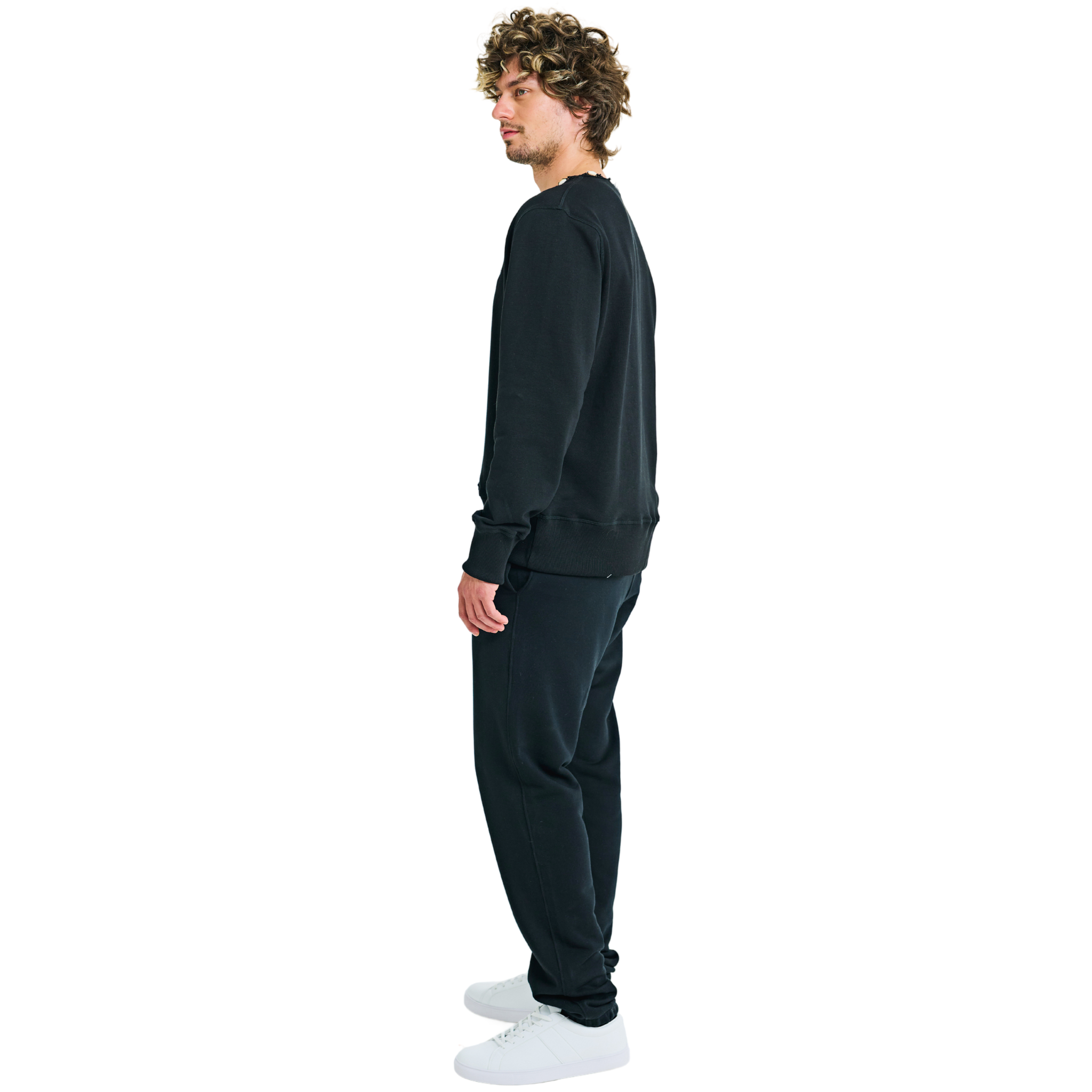 Side view of male model in unisex black sweatshirt with embroidered logo and handmade braided shell neckline