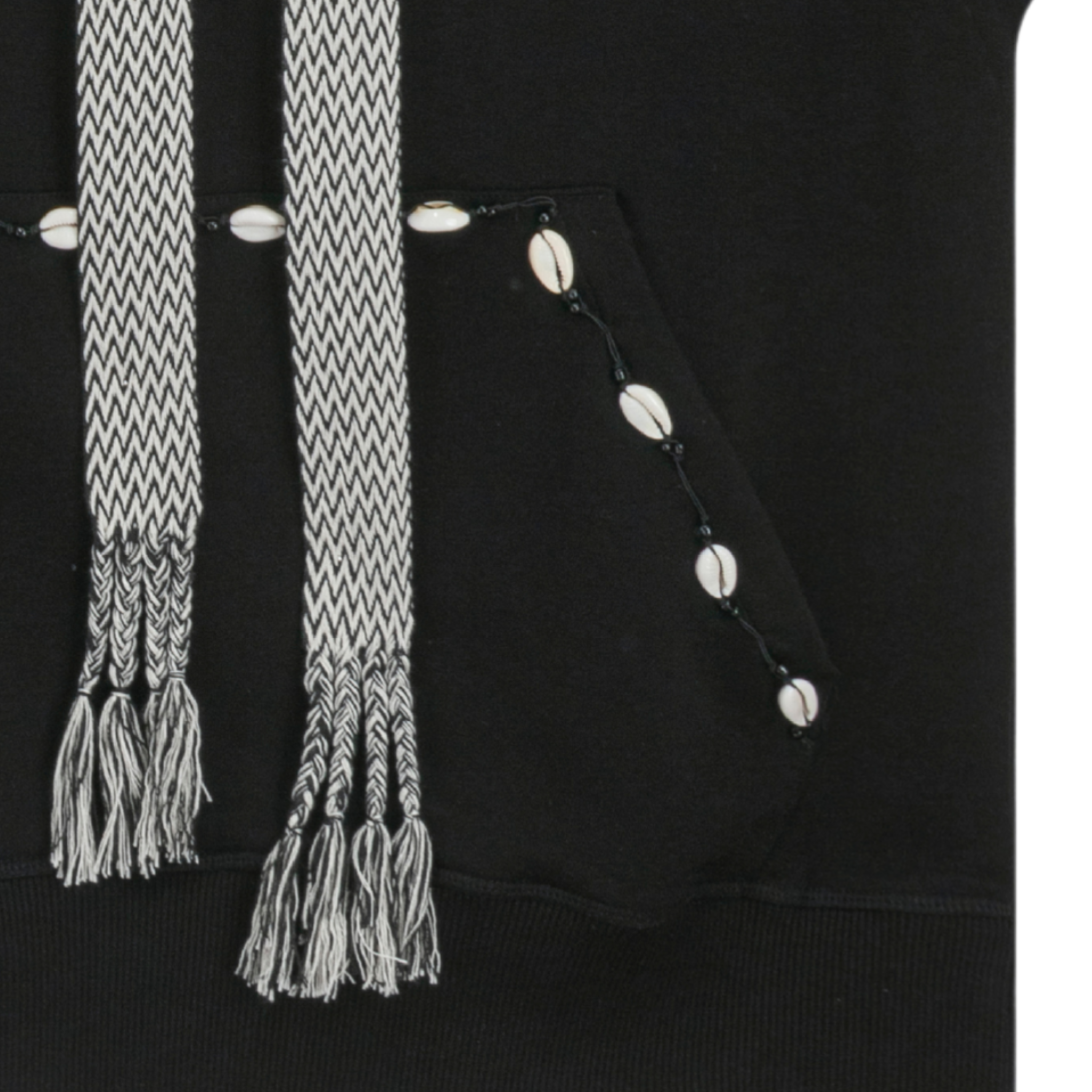 Close-up of woven straps with braided tassels and cowrie shell details on hoodie