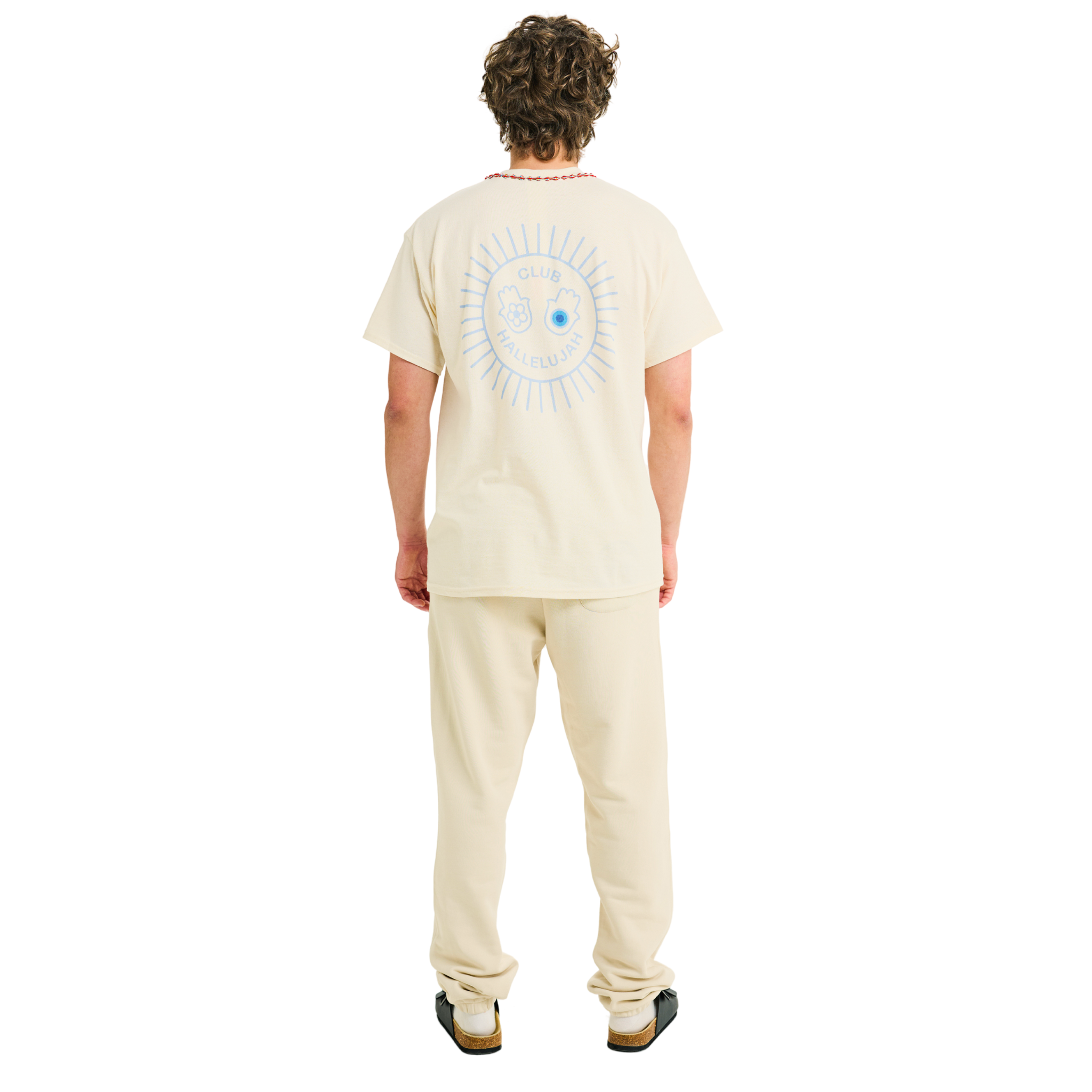 Male model wearing natural cotton T-shirt, back view, showing light blue sunburst print and braided neckline, full body