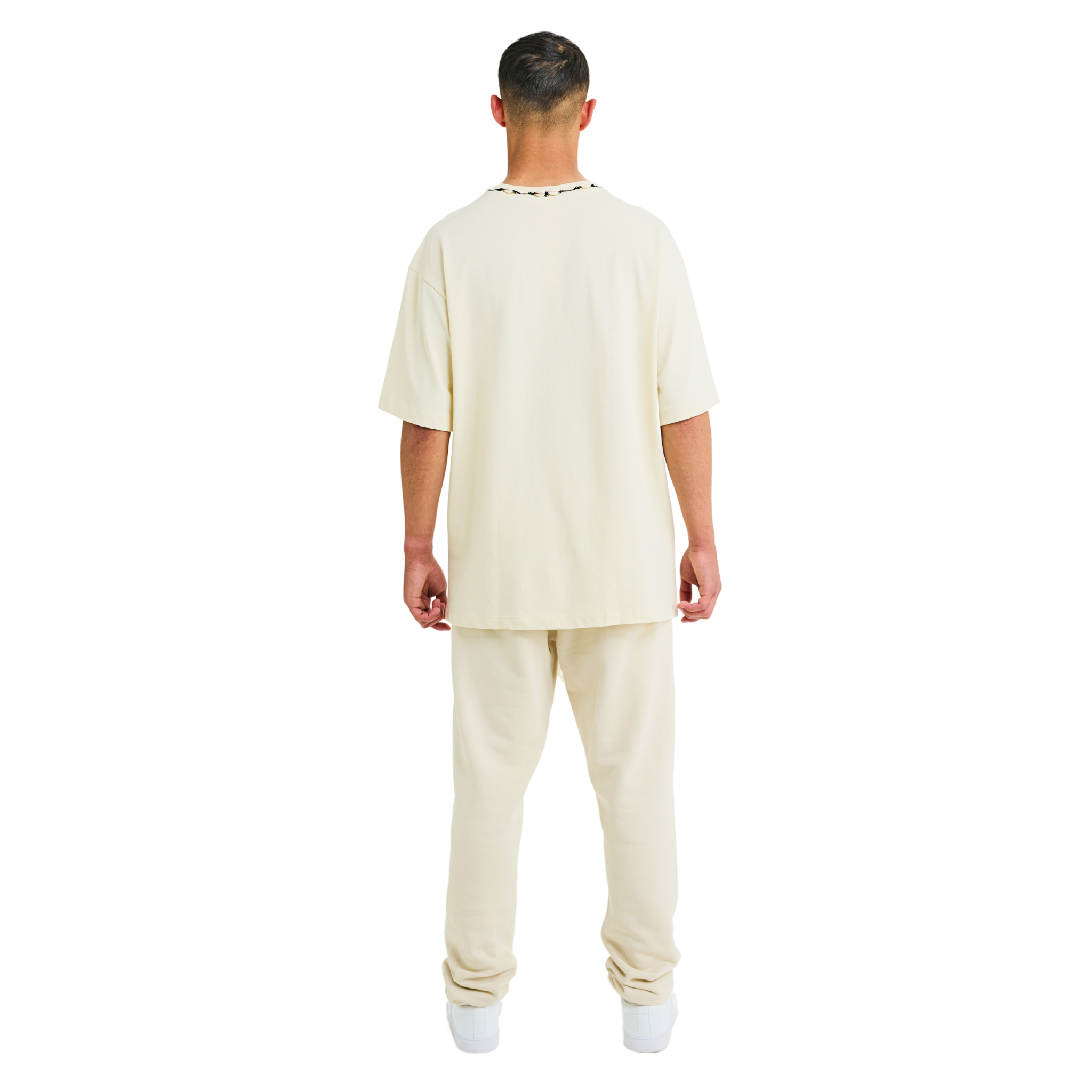 Back view of male model wearing unisex sabbia oversized T-shirt with handmade braided neckline and relaxed fit