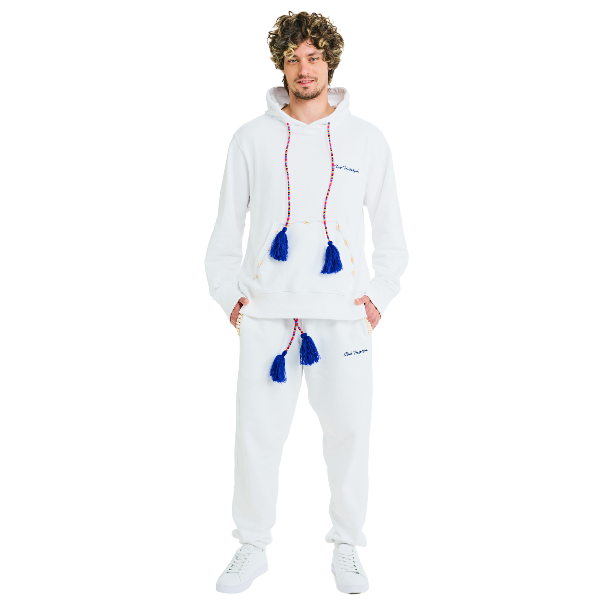 Front view of male model wearing unisex white hoodie and sweatpants, 100% cotton, handmade drawstrings with blue tassels, cowrie shell details, Club Hallelujah logo embroidery