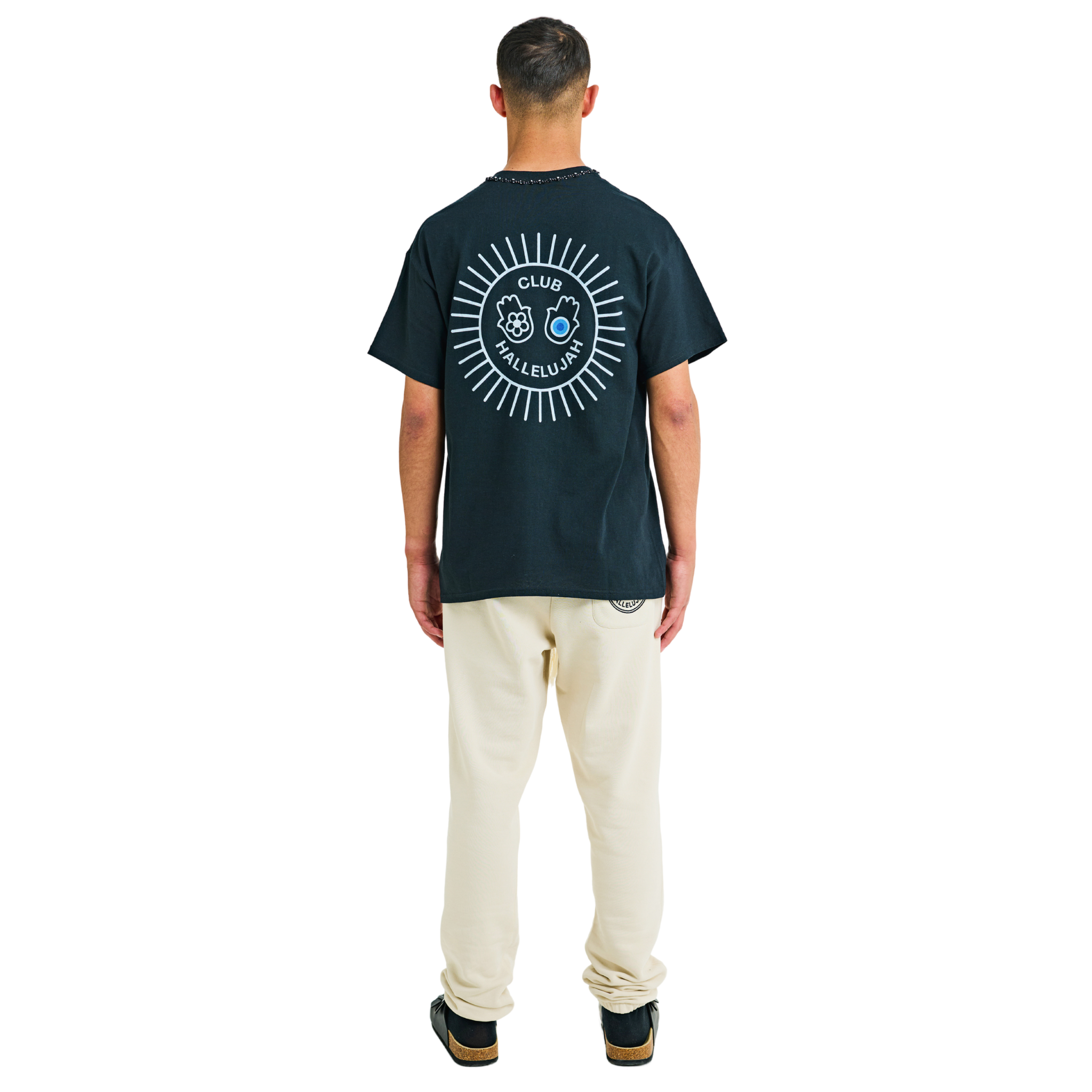 Male model wearing black T-shirt, back view, showing white sunburst print and braided neckline