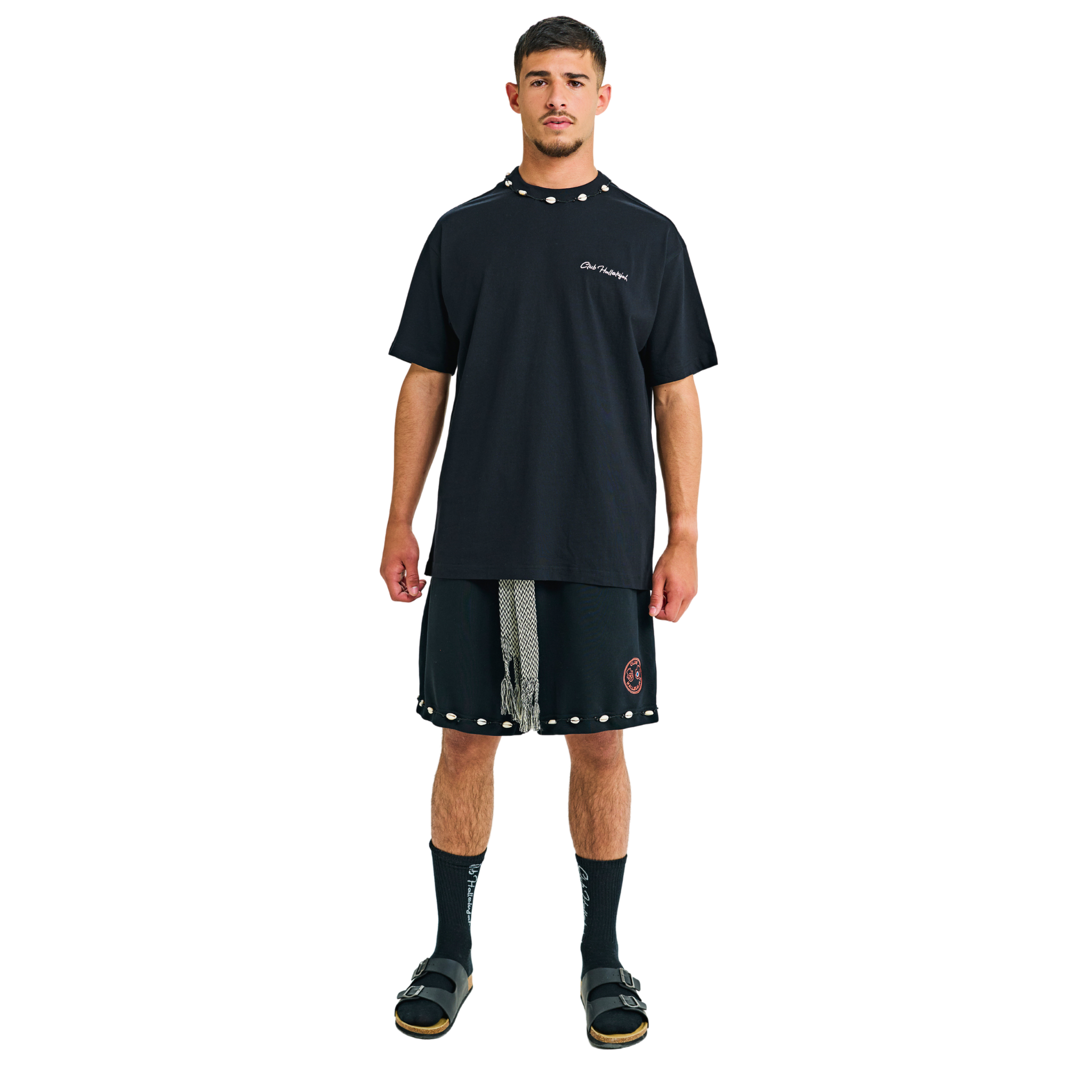 Model wearing black T-shirt with small front logo and cowrie shell neckline, front view