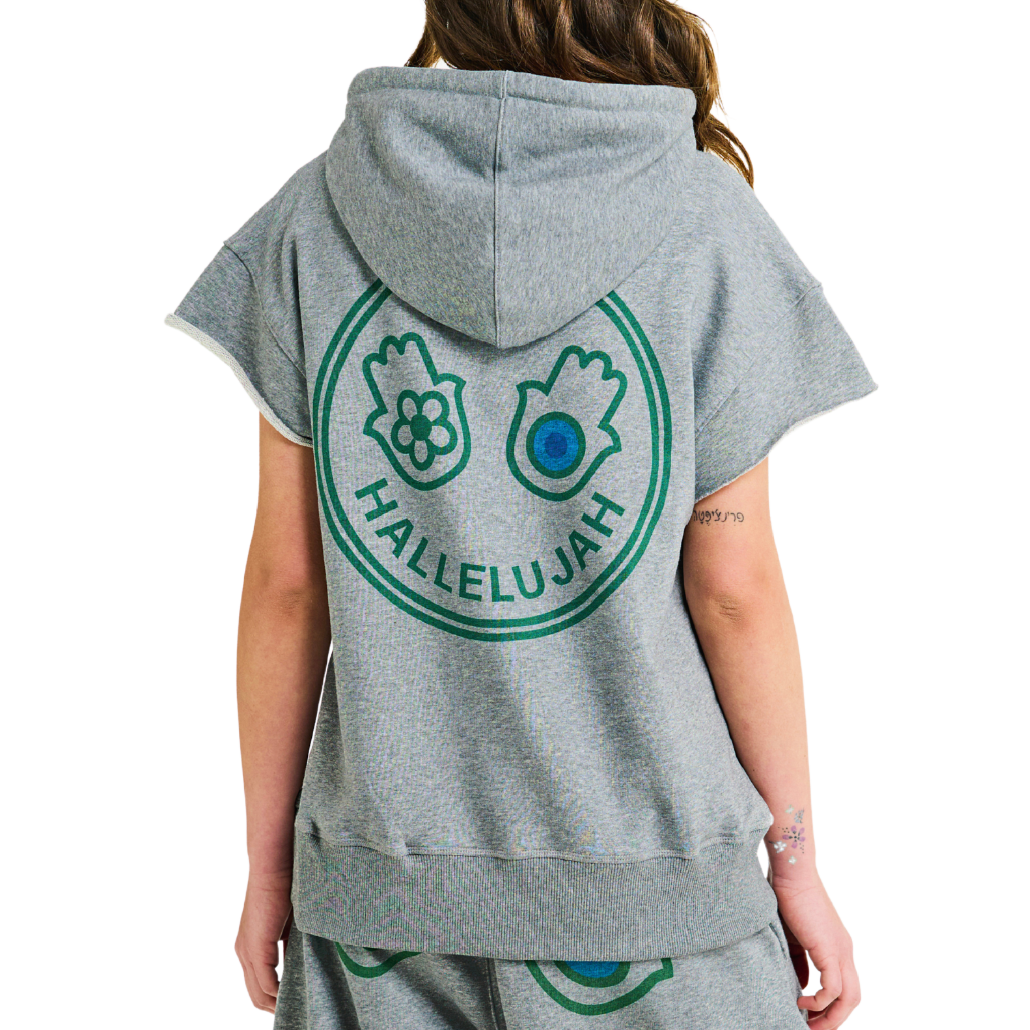 Female model showing back of unisex gray melange hoodie with Club Hallelujah hamsa hands logo, handmade details, 100% cotton, cowrie shells
