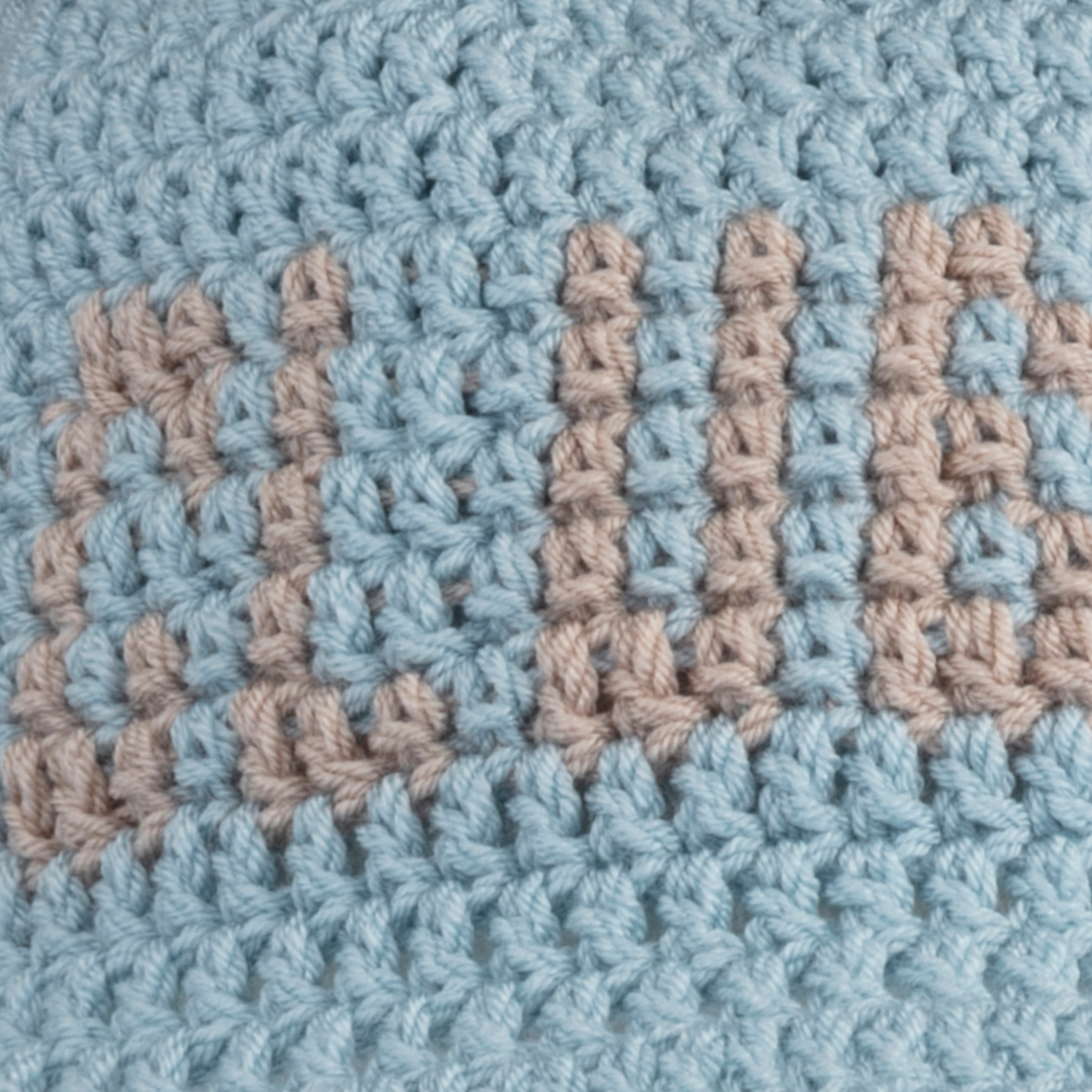 Close-up of orange 'CLUB HALLELUJAH' lettering on baby blue hand-crocheted bucket hat