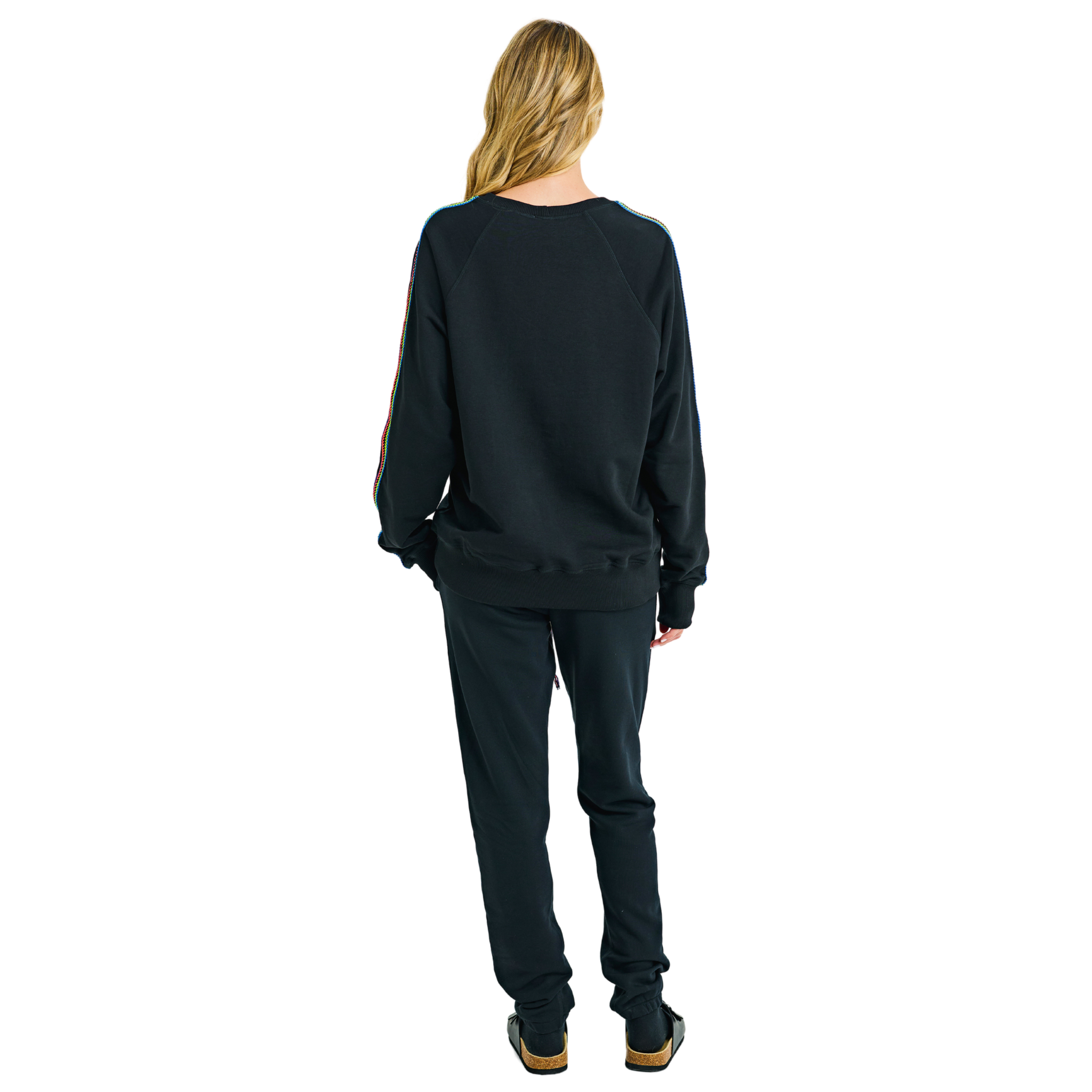 Back view of female model in black oversized raglan sweatshirt with plain back and handmade braided sleeve details
