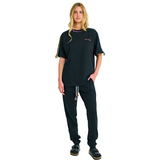 Front view of female model wearing unisex black sweatpants with braided neon cords and classic straight-leg silhouette