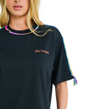 Close-up of embroidered chest logo and handmade braided multicolor details on black oversized T-shirt neckline