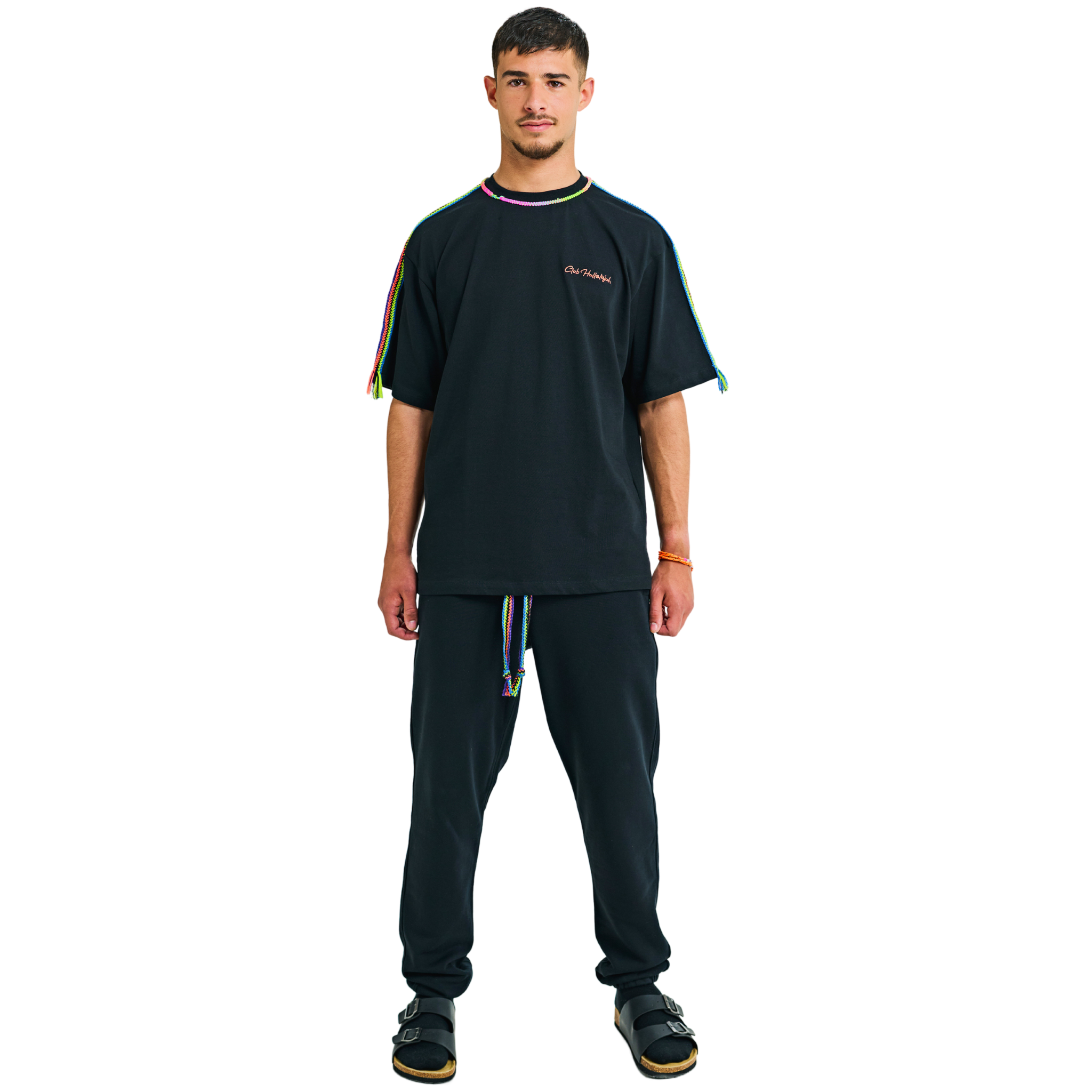 Male model front view in black oversized T-shirt with embroidered logo and braided multicolor shoulders