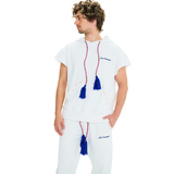 Side view of male model wearing unisex white hoodie with blue tassels and cowrie shell pocket trim