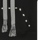  Close-up of woven straps with braided tassels and cowrie shell details on hoodie