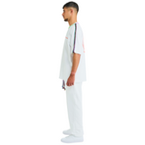 Side view of male model wearing white oversized T-shirt with handmade braided shoulder details
