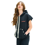 Female model front view in Mogador Nights short-sleeve hoodie with woven straps and cowrie shells