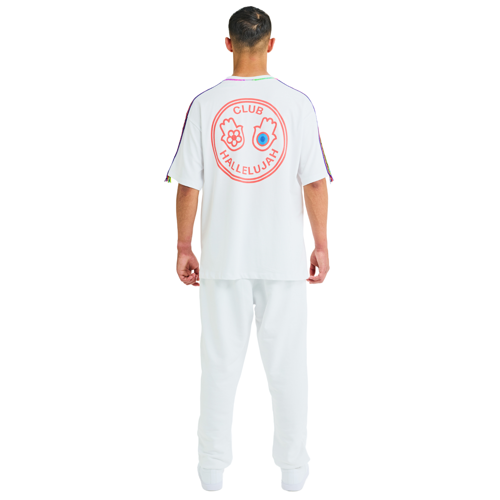Back view of male model wearing white oversized T-shirt with large printed graphic logo and braided shoulders