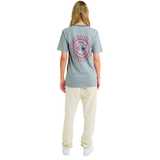 Female model wearing ash grey mélange T-shirt, back view, showing red sunburst print and braided neckline