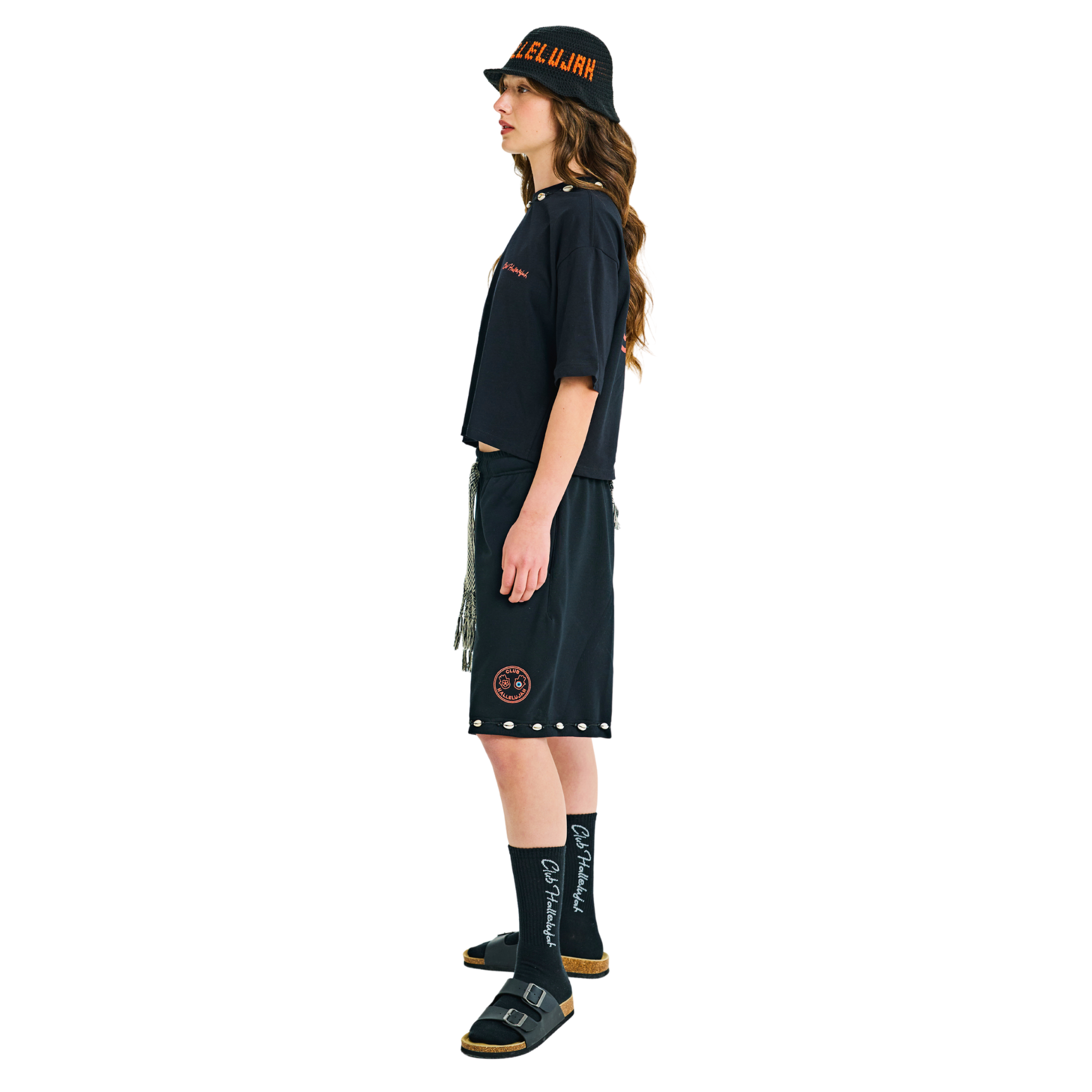 Model in black crop top, side view, showing back hamsa prints and braided cord detail