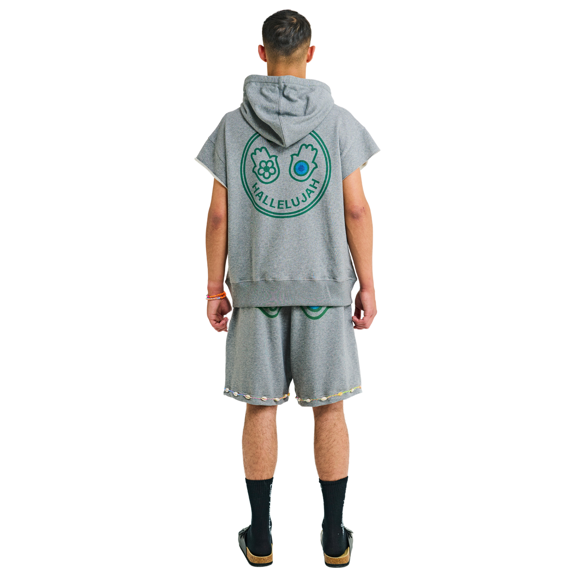 Male model showing back of unisex gray melange hoodie with Club Hallelujah hamsa hands logo, handmade details, 100% cotton, cowrie shells
