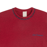 Close-up of red mélange T-shirt neckline with handmade braided ribbon and small front logo