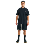 Model wearing black T-shirt with small front logo and cowrie shell neckline, front view