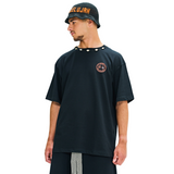 Male model wearing black oversized T-shirt, side view, showing cowrie shell neckline and hamsa back print