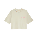 Oat milk organic cotton crop top with pink 'Club Hallelujah' embroidery and cowrie shell neckline, front view